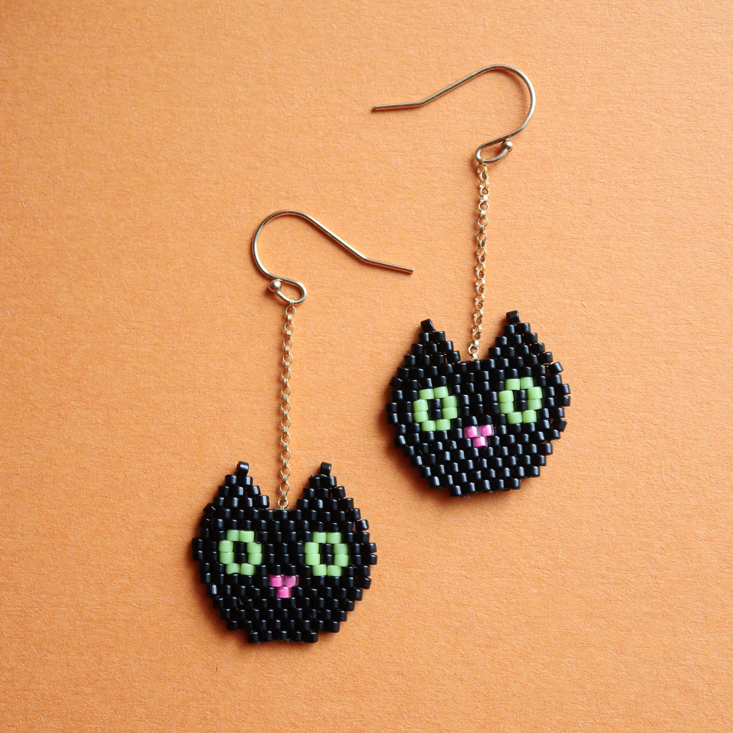 beaded earrings with black cat heads and green eyes